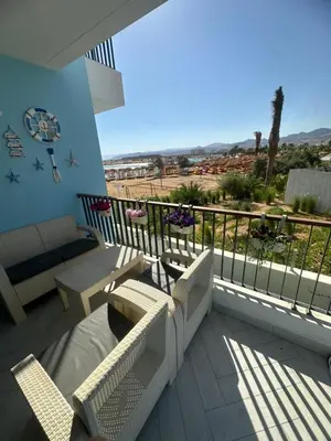 a balcony with a couch and chairs on a balcony at شقه شاطئيه in Aqaba