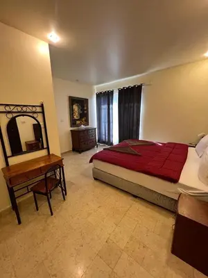 a bedroom with a bed and a table and a mirror at Sossita Guesthouse & Boutique Resort