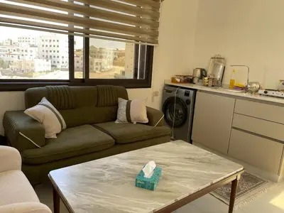 a living room with a couch and a table at For Rent ,New Furnished Rooftop in Shafa Badran in Amman