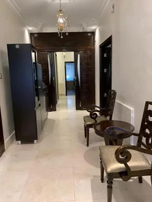 a hallway with chairs and a table in a building at Shmeisani Cozy Apartment in Amman