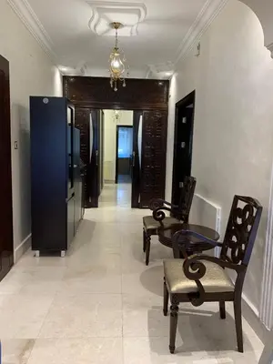 a hallway with chairs and a table in a room at Shmeisani Cozy Apartment in Amman