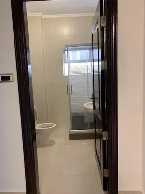 a bathroom with a toilet and a glass door at Shmeisani Cozy Apartment in Amman