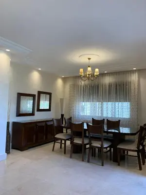 a dining room with a table and chairs at Shmeisani Cozy Apartment in Amman
