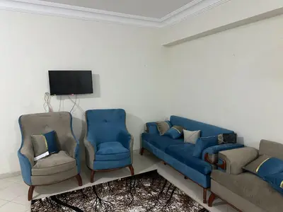a living room with two blue couches and two chairs at Jordan house in Al Bāriḩah