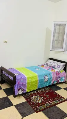 a bedroom with a bed with a colorful quilt at Jordan house in Al Bāriḩah