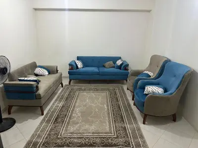 a living room with two chairs and a blue couch at Jordan house in Al Bāriḩah