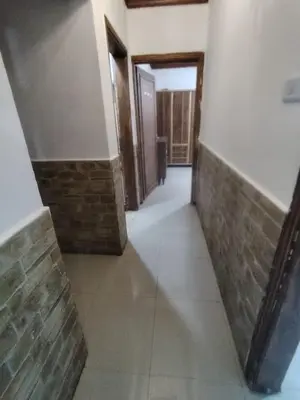 an empty hallway with brick walls and a hallway with doors at الشهم 10 in Irbid