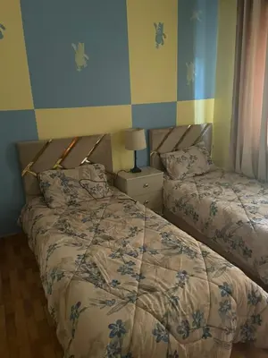 two beds in a bedroom with blue and yellow walls at Luxurious furnished apartment for rent with hotel finishes in Amman