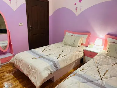 a bedroom with two beds and a purple wall at Luxurious furnished apartment for rent with hotel finishes in Amman