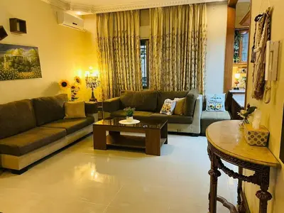 a living room with a couch and a table at Luxurious furnished apartment for rent with hotel finishes in Amman