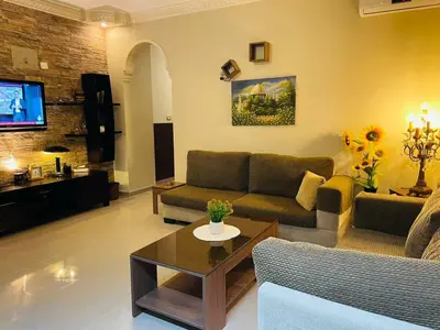 a living room with a couch and a table at Luxurious furnished apartment for rent with hotel finishes in Amman