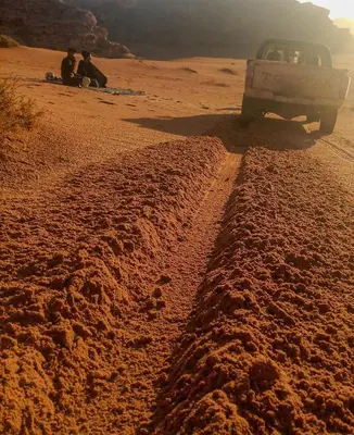 a truck driving down a dirt road in the desert at Moon House & Sunset Tour in El Quweira