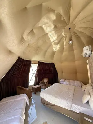 a room with two beds and a ceiling at Nala Luxury Camp & Bubbles Hotel in Wadi Rum