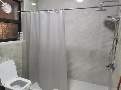 a bathroom with a shower curtain and a toilet at 2 Master Bedroom Deluxe Apartment Queen Alia Airport Families Women ONLY in Amman