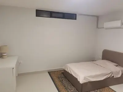 a white room with a bed and a desk at 2 Master Bedroom Deluxe Apartment Queen Alia Airport Families Women ONLY in Amman