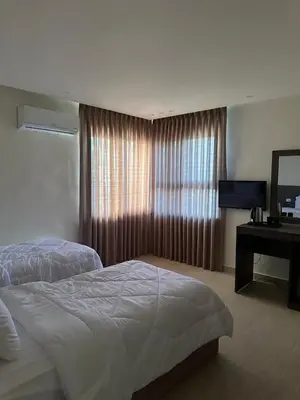 a bedroom with a bed and a desk and a window at Midtown Lweibdeh Hostel in Amman