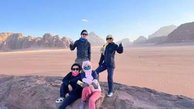 a group of women standing on a rock in the desert at wadi rum planet camp in Disah