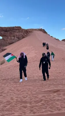 a group of people flying a kite in the desert at wadi rum planet camp in Disah