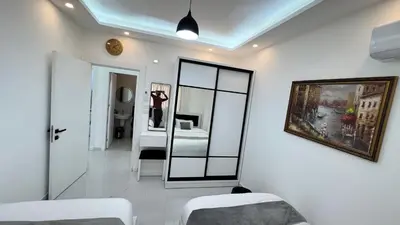 a white room with a mirror and a bed at شقة مفروشة ثلاث غرف الجاردنز in Amman