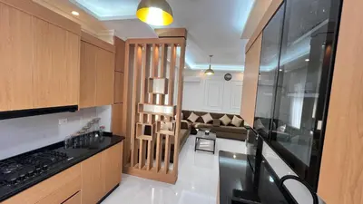 a kitchen with wooden cabinets and a couch at شقة مفروشة ثلاث غرف الجاردنز in Amman