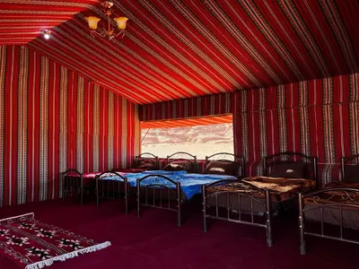 a room with four beds and a window at Stars Night Camp in Wadi Rum