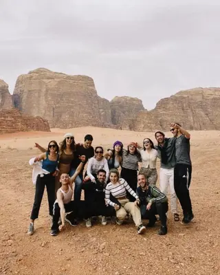 a group of people posing for a picture in the desert at Stars Night Camp in Wadi Rum
