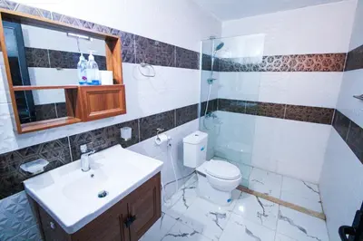 a bathroom with a toilet and a sink and a shower at Dune Camp Tours in Wadi Rum