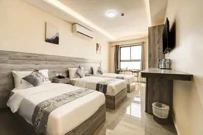 a hotel room with two beds and a television at aqaba hills hotel in Aqaba