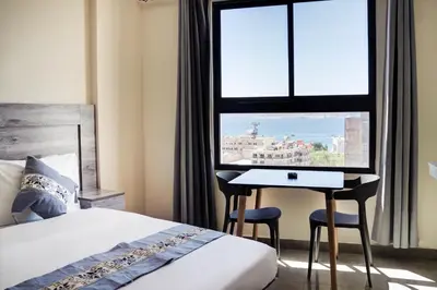 a bedroom with a bed and a desk and a window at aqaba hills hotel in Aqaba