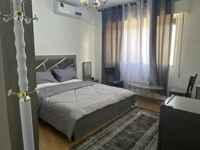 a bedroom with a bed and a table and curtains at One bedroom apartment in the heart of west Amman in Amman