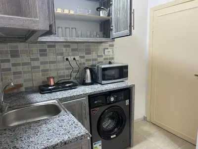 a kitchen with a washing machine and a microwave at One bedroom apartment in the heart of west Amman in Amman