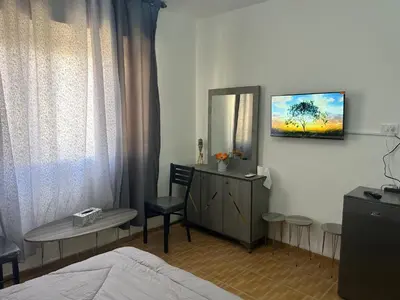 a bedroom with a bed and a mirror and a table at One bedroom apartment in the heart of west Amman in Amman