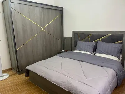 a bedroom with a large bed with a wooden headboard at One bedroom apartment in the heart of west Amman in Amman
