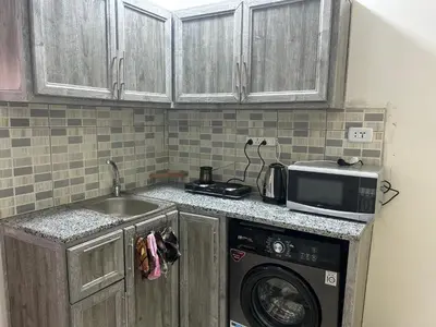 a kitchen with a sink and a washing machine at One bedroom apartment in the heart of west Amman in Amman