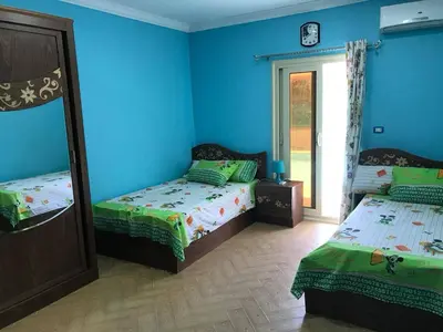 two beds in a room with blue walls at Yousef chalet in Amman
