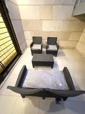 a bed and two chairs and a table in a room at Brand New Stylish Luxe Apartment Near US Embassy Abdoun in Amman