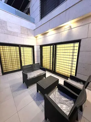 a room with benches and tables in a building with windows at Brand New Stylish Luxe Apartment Near US Embassy Abdoun in Amman