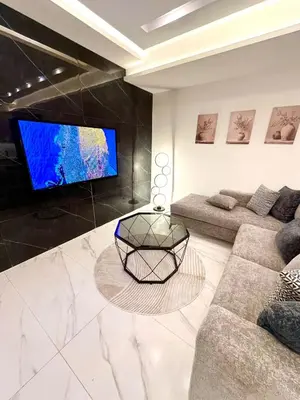 a living room with a couch and a tv at Brand New Stylish Luxe Apartment Near US Embassy Abdoun in Amman
