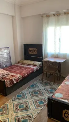 a bedroom with two beds and a table and a rug at Family house in Petra