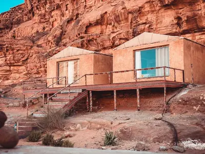 a house on a cliff with a building on it at Martian Desert Camp in Wadi Rum