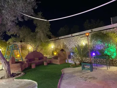 a garden at night with a playground and lights at مزرعه الخال in Al Kafrayn