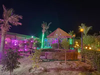 a building with colorful lights on it at night at مزرعه الخال in Al Kafrayn