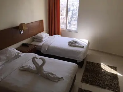 a hotel room with two beds with a swan on them at Zaina Plaza Hotel in Amman