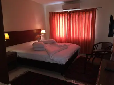 a bedroom with a bed with a red curtain at Zaina Plaza Hotel in Amman