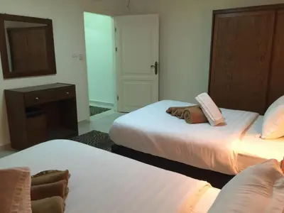 a hotel room with two beds and a mirror at Zaina Plaza Hotel in Amman