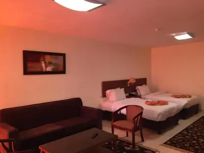 a hotel room with two beds and a couch at Zaina Plaza Hotel in Amman