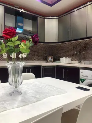 a vase of roses sitting on a table in a kitchen at تقاطع الحرمين -خلف برجر كينج دوار الكيلو in Amman