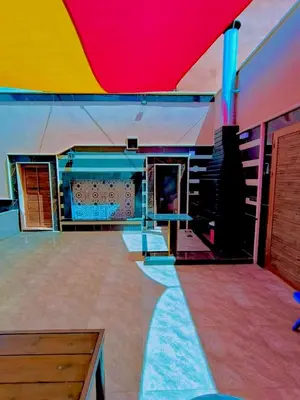 a large room with a colorful ceiling and stairs at شاليه كل الفصول in Dawqarah