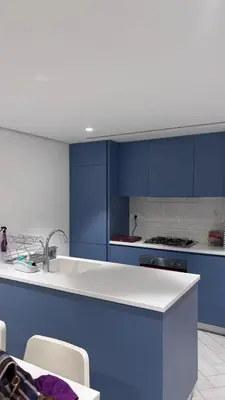 a kitchen with blue cabinets and a white counter top at العقبة in Aqaba