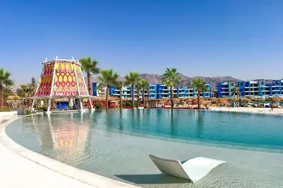 a swimming pool with a paper boat in the water at Ayla Oasis Golf Apartment - Ayla Vista in Aqaba
